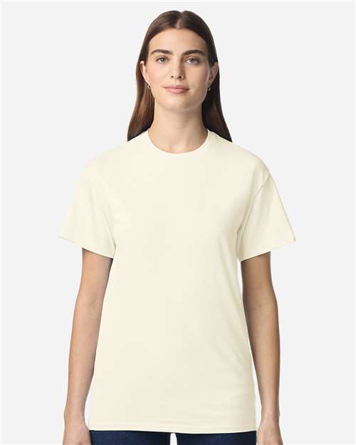 Gildan 100 plain T-shirts in various colors, folded and stacked, on a display shelf.
