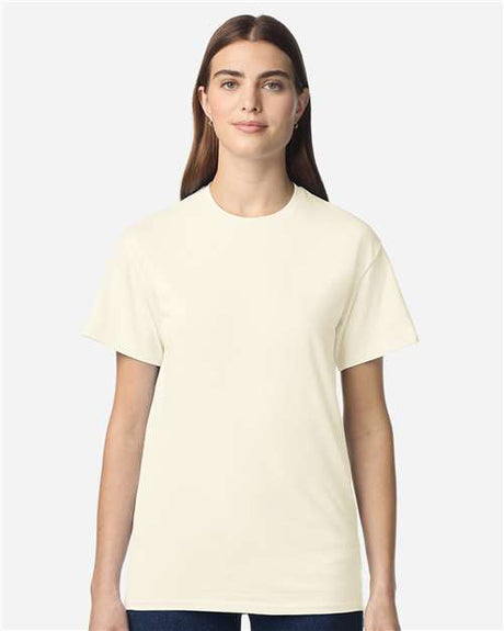 Gildan 100 plain T-shirts in various colors, folded and stacked, on a display shelf.