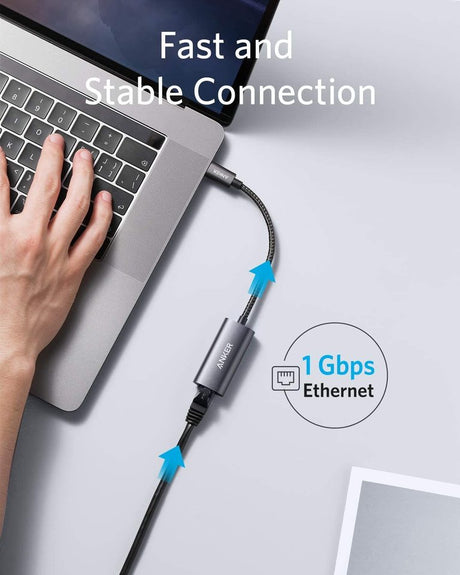 Anker PowerExpand USB-C to Gigabit Ethernet Adapter connected to a laptop with visible Ethernet port and cable plugged in.