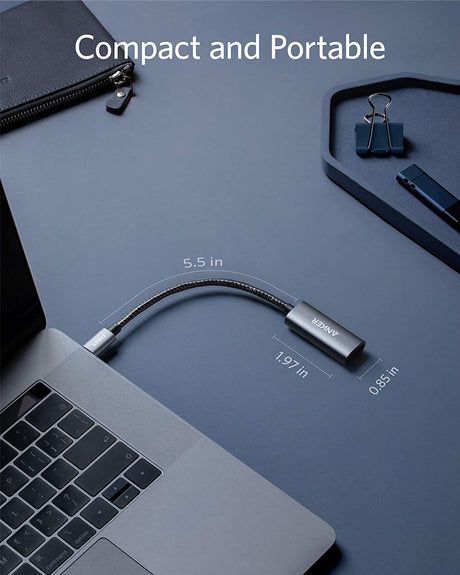 Anker PowerExpand USB-C to DisplayPort adapter connected to a laptop, showing a clear DisplayPort connector and cable.